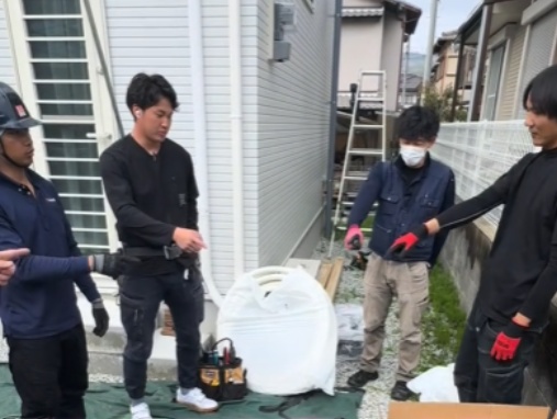 屋外で先輩と打ち合わせしながら現場に慣れていく様子